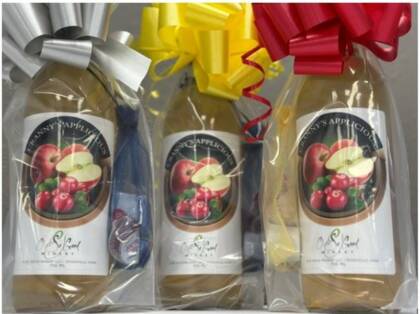 packaged kit showing cranapple wine, creamer, sugar, and cinnamon wrapped together and topped with a bow.