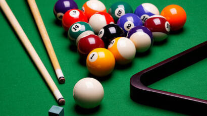 closeup of pool table with pools balls and rack